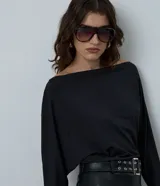 Blusa de microfibra con diseño de manga murciélago, escote amplio y caída holgada. Prenda de manga larga confeccionada en tejido ligero y resistente.
