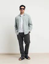 Sobrecamisa verde de manga larga con cuello camisero, cierre frontal con botones y bolsillo de parche en el pecho.