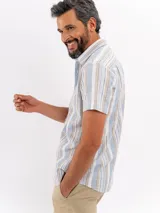 Camisa de manga corta efecto lino de Cuatroases, con estampado de rayas verticales en color azul y fondo beige. Presenta cuello camisero clásico y cierre frontal con botones blancos.