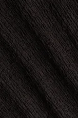Pantalón de punto color negro con efecto arrugado, tiro alto, cintura elástica y piernas amplias.