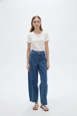 Pantalón jean azul de tiro bajo y corte ancho, con estampado de rayas verticales y diseño floral sutil.