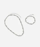 Kit de collar y pulsera plateados de metal, con diseño de eslabones y dijes intercalados en forma de trébol de cuatro hojas.