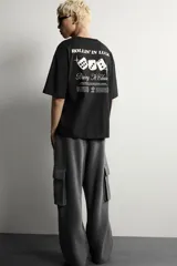 Camiseta relaxed fit negra de cuello redondo y manga corta, con pequeños estampados a contraste en el delantero y diseño en la espalda.