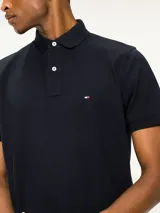 Chomba Tommy Hilfiger azul marino de algodón, con cuello clásico, cartera de tres botones y logo bordado en el pecho.