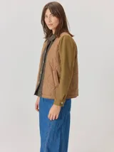 Campera de diseño híbrido con frente acolchado en color tostado, solapas y cuello en tejido de lana con patrón de cuadros tipo príncipe de gales, y mangas en paño de lana color azul marino. Cuenta con cierre frontal de botones.