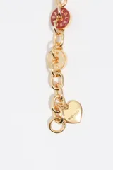 Pulsera de cadena con eslabones plateados y charms circulares esmaltados en diversos colores con logos grabados. Incluye un dije de corazón y cierre de mosquetón.