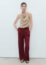 Pantalón de vestir color bordó, de tiro medio y diseño recto con pinzas delanteras. Cuenta con trabillas para cinturón, bolsillos laterales y cierre oculto con botón, gancho y cremallera.