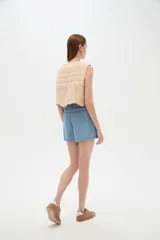 Short celeste de tiro medio, con bolsillos laterales y corte ancho.