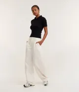 Blusa polo beige de manga corta, confeccionada en tejido canelado de rib de algodón con elastano, que proporciona un ajuste cómodo y una caída ajustada.