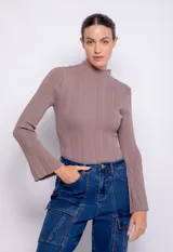 Polera color lila de tejido acanalado, con cuello alto y mangas largas acampanadas.