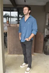 Camisa celeste de lino con cuello clásico, manga larga con puños abotonados y cierre frontal con botones.