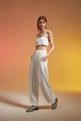 Top corto color crudo, con breteles finos y escote redondo.