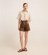 Short de sarga color marrón con cintura media y bolsillos frontales. Incluye un cinturón de tela del mismo material para anudar en la parte delantera.