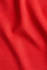Remera roja de manga corta, cuello redondo y calce entallado, confeccionada en tejido de punto fino acanalado.