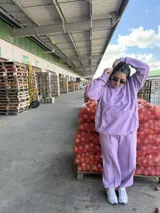 Pantalón deportivo de tiro alto, color lavanda, con bolsillos laterales y puños elásticos en los tobillos.