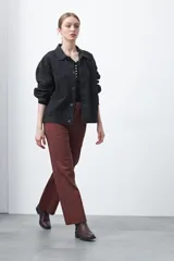 Pantalón ancho de tiro alto, color negro, con pretina y doble botón metalizado.