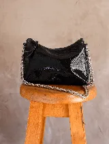 Cartera tipo media luna de cuero negro con acabado charolado, cierre superior y cadena metálica plateada como correa.