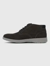 Bota urbana de caña baja confeccionada en cuero gamuzado color marrón oscuro, con cordones al tono y suela de poliuretano gris con tecnología de amortiguación.