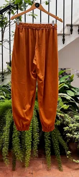 Pantalón tipo babucha color camel, con cintura y puños elastizados, bolsillos delanteros y confeccionado en 100% algodón.