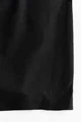 Pantalón corto deportivo negro de doble capa con cintura elástica fruncida y calzas ciclistas integradas.