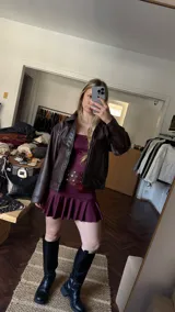Vestido corto bordó de jersey con lycra, escote strapless y falda con volados.