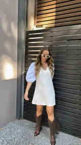 Vestido corto color crudo, con escote en V y mangas 3/4 abullonadas con detalles de calado.