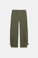 Pantalón cargo de tiro medio confeccionado en algodón, con diseño de pierna ancha y costuras verticales. Presenta bolsillos laterales y bolsillos tipo cargo con solapa en las piernas. El bajo es ajustable mediante trabillas con hebilla metálica.