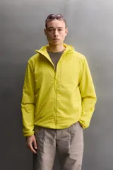 Chaqueta acolchada Zara Athleticz de color amarillo, confeccionada en tejido técnico y ligero. Cuenta con cuello subido y capucha, manga larga con puños elásticos, bolsillos frontales con cierre de cremallera oculta y cierre frontal con cremallera.