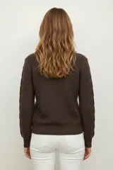 Sweater de punto acrílico color crema, con cuello redondo y diseño de punto trenzado (cable knit) en todo el cuerpo y mangas.