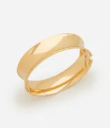 Pulsera brazalete rígida de diseño cerrado y ancho medio, con acabado liso y brillante. Cuenta con un sistema de apertura con resorte lateral para facilitar su colocación.