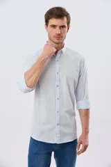 Camisa de lino rayada de manga larga, con cuello camisero, cierre frontal de botones y bordado sutil en el pecho.