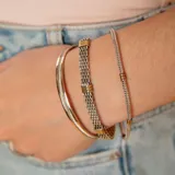 Pulsera de diseño fino confeccionada en plata 925 con detalles en oro 9k, caracterizada por su estructura de cadena tipo serpiente con secciones decorativas en oro.