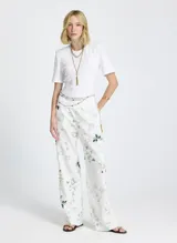 Remera blanca de tejido de punto, corte recto, cuello redondo, manga corta y cierre de lazo en la espalda.