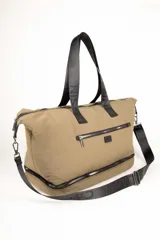 Bolso de gran capacidad color beige, con asas fijas superiores y correa de cinta negra desmontable y regulable. Presenta un bolsillo externo con cierre, un compartimento inferior con cierre y logo de la marca Daniel Cassin en el frente.