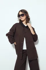 Sobrecamisa tipo Barn Jacket color marrón oscuro, de algodón con elastano, silueta relajada y estructura firme. Presenta cierre frontal con botones metálicos, cuello negro, bolsillos aplicados y pespuntes visibles.