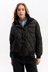 Campera puffer negra con diseño matelaseado en rombos, capucha integrada, cierre frontal y puños elásticos.