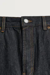 Pantalón jeans de corte recto y ajuste holgado, confeccionado en denim de algodón rígido. Presenta diseño clásico de cinco bolsillos, cierre frontal con cremallera y botón, con un acabado de lavado claro.