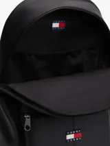 Mochila Tommy Jeans Essential Daily en color negro, confeccionada en poliuretano y poliéster. Cuenta con un compartimento principal con cierre de cremallera, un bolsillo exterior frontal con cierre y el logo bordado de la marca. Dispone de asa superior y correas ajustables acolchadas.
