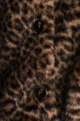 Campera de piel sintética con estampado de leopardo, cuello redondo y cierre frontal con botones. Presenta un diseño de corte recto y forro interior.