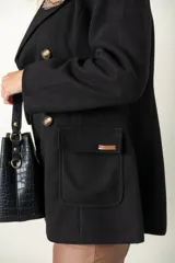 Blazer verde con corte clásico, doble botonadura y bolsillos con solapa.