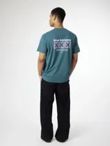 Remera verde oscuro con cuello redondo y mangas cortas de corte regular, con estampado gráfico trasero que incluye el texto "blue banana" y tres cruces.