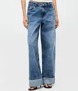 Pantalón wide leg de tiro bajo confeccionado en denim de algodón. Presenta un diseño de pierna amplia con ruedo doblado, cintura con pasadores y cierre frontal con botón y cremallera.