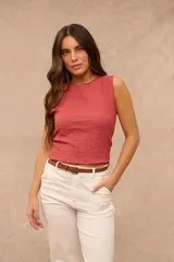 Blusa sin mangas de corte recto, color terracota, con textura arrugada y escote redondo.