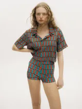 Microshort de tiro alto confeccionado en lycra con estampado geométrico en tonos naranja y turquesa.