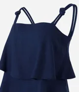 Blusa femenina color azul marino, sin mangas, con breteles anchos que tienen nudos decorativos y escote recto. Presenta capas sobrepuestas en la parte delantera que crean un leve volumen.