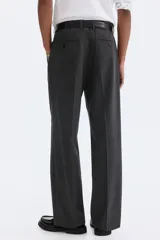 Pantalón de corte relajado en color gris oscuro, con cintura elástica, cierre de botón y cordón de ajuste oculto. Presenta raya marcada en las piernas, bolsillos laterales al bies y bolsillos traseros ribeteados con botón.