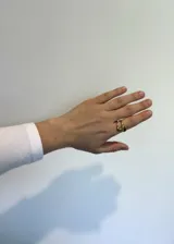 Anillo dorado de acero inoxidable con forma de nudo abierto.