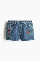Short de denim de algodón rígido, color azul claro, con cinco bolsillos y diseños florales bordados en la parte delantera. Modelo de tiro alto con cierre de botón.