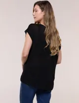 Blusa negra de tejido de punto fino con hilos de lúrex brillante, escote redondo amplio, mangas cortas con hombros caídos y silueta semi holgada.