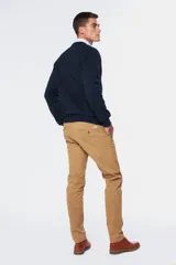 Pantalón de gabardina azul marino con corte slim fit, tiro medio y cierre de botón. Cuenta con bolsillos traseros con botón y etiqueta de marca.